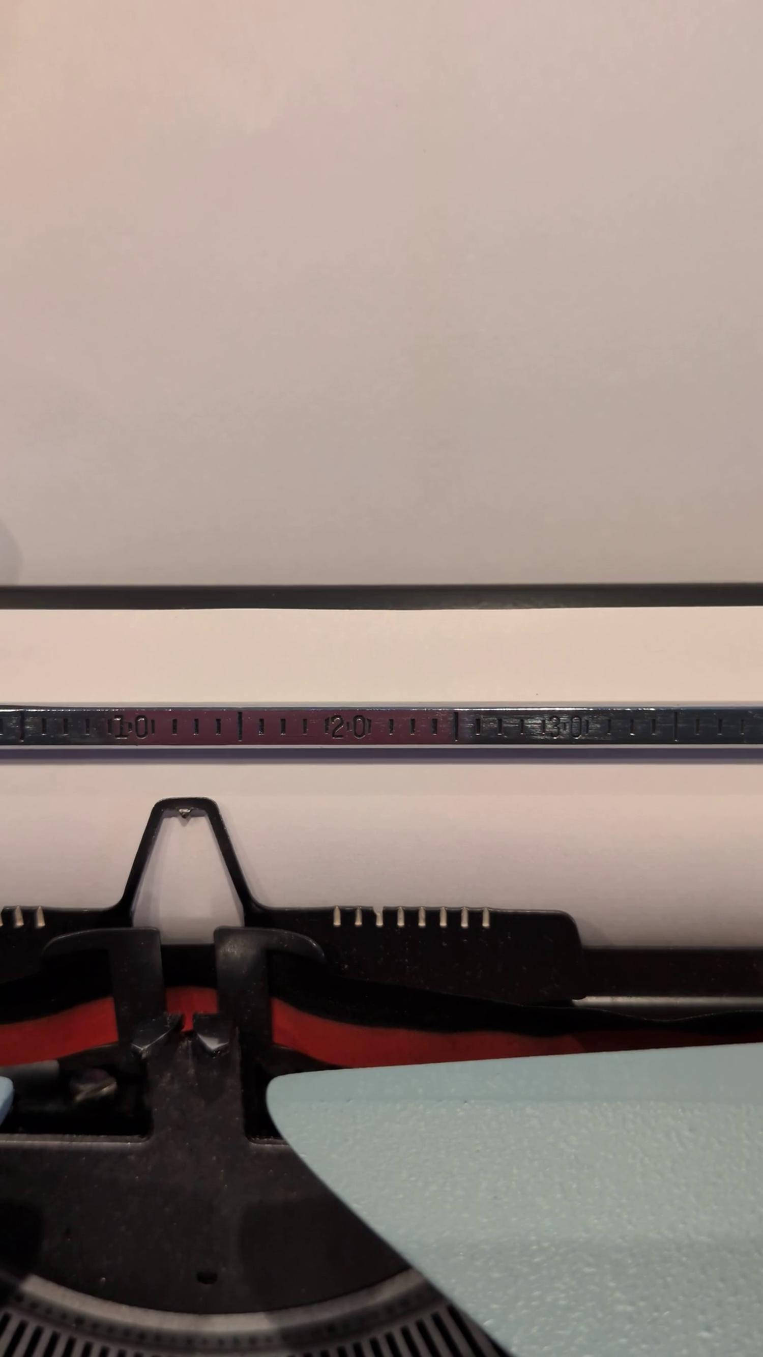 Close-up of a typewriter head typing out the start of the New Hege Story
