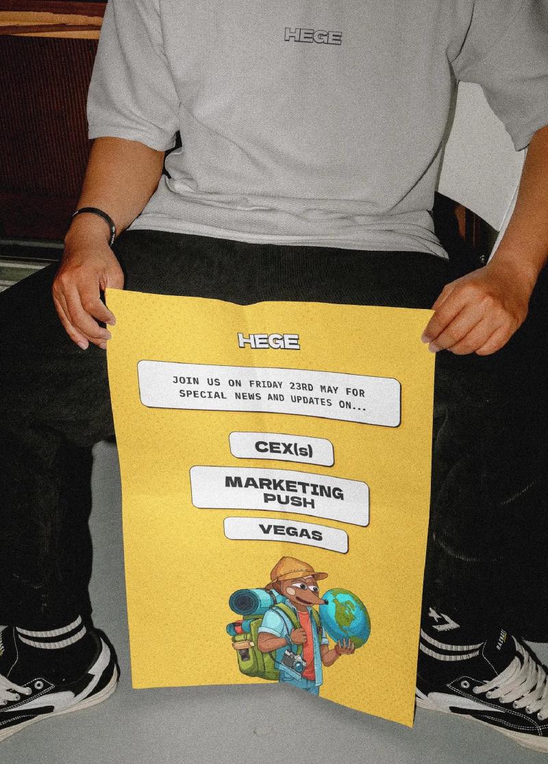 A Hegend holding a yellow HEGE poster between his legs
